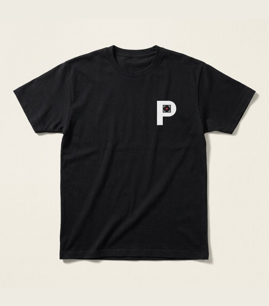 En tryckritning av en t-shirt med tryckytan på vänster bröst ritas upp och blir en svart t-shirt med Profilagentens logga tryckt i vitt och rött